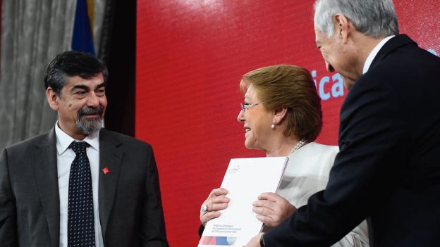 La Presidenta de Chile, Michelle Bachelet, recibe del Ministro de Relaciones Exteriores de Chile, Heraldo Muñoz, y del anterior Director de la AGCID, Ricardo Herrera, la Política y Estrategia de Cooperación Internacional de Chile para el Desarrollo “Chile Coopera”, el pasado mes de julio. Fotografía: AGCID.